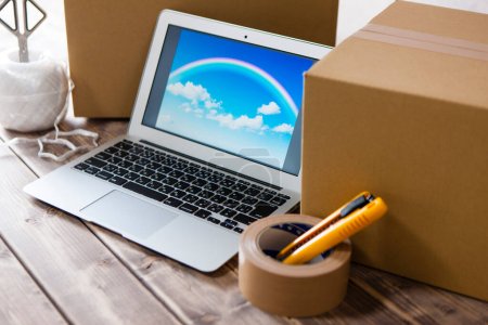 Téléchargez les photos : Boîtes en carton avec ordinateur portable près du bureau en bois avec écran - en image libre de droit