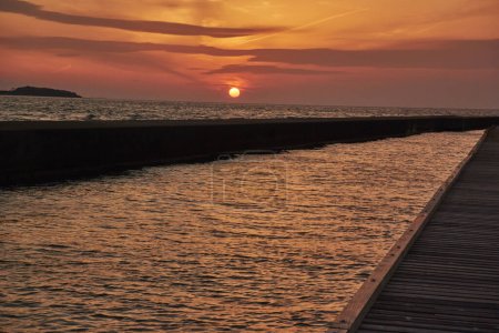 Téléchargez les photos : Coucher de soleil sur la jetée dans la mer - en image libre de droit