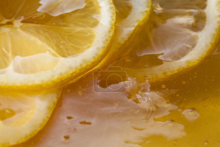 Téléchargez les photos : Vue rapprochée du citron frais tranché avec du miel, fond alimentaire - en image libre de droit