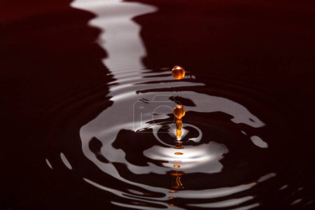 Foto de Macro foto de círculos en el agua oscura, vertiendo líquido negro - Imagen libre de derechos
