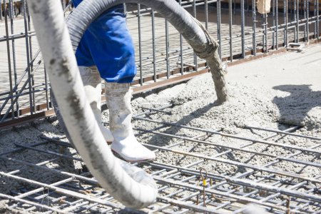 Téléchargez les photos : Travailleur de la construction sur le chantier, couler des fondations en béton - en image libre de droit
