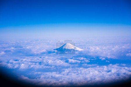 Photo for Beautiful aerial view of mountain Fuji surrounded with white fluffy clouds and blue sky. Japan - Royalty Free Image