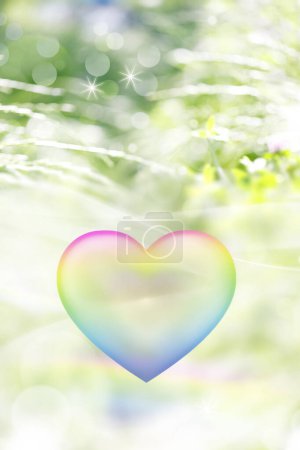 Foto de Colorido arco iris corazón burbuja y bokeh luces en el fondo de hierba verde - Imagen libre de derechos