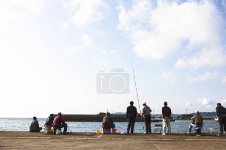 men fishing at the seashore on a sunny day