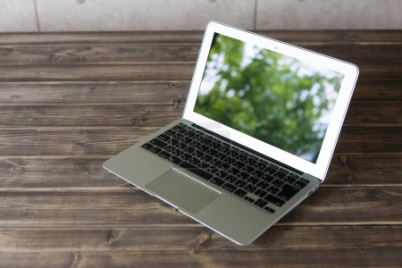 Téléchargez les photos : Un ordinateur portable avec écran sur table en bois - en image libre de droit