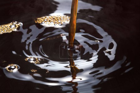 Photo for Macro photo of circles on the dark water, pouring black liquid - Royalty Free Image