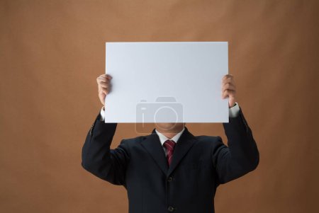 Téléchargez les photos : Photo recadrée d'un homme d'affaires tenant du papier vierge avec espace de copie pour message - en image libre de droit