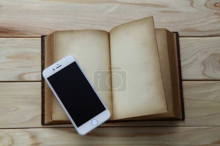 Photo for Mobile phone with black screen and old book with blank pages on wooden background - Royalty Free Image