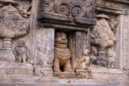 Téléchargez les photos : Sculpture sur pierre sur le mur du temple hindou Prambanan dans la région spéciale de Yogyakarta, dans le sud de Java, Indonésie, dédié aux Trimurti, l'expression de Dieu comme le Créateur (Brahma), le Conservateur (Vishnu) et le Destructeur (Shiva) - en image libre de droit