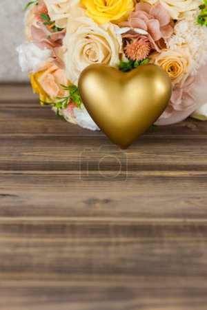 Foto de Ramo de bodas con flores y corazón dorado en la mesa de madera. espacio para texto - Imagen libre de derechos