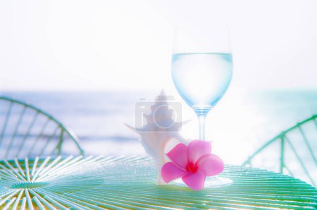 Foto de Fondo de verano con plumeria flor, concha y vino con agua en la playa - Imagen libre de derechos