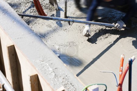 Téléchargez les photos : Travailleur utilisant du ciment pour la fabrication de plancher sur le chantier - en image libre de droit