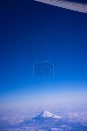 Téléchargez les photos : Belle vue aérienne de la montagne Fuji entourée de nuages blancs et duveteux et de ciel bleu. Japon - en image libre de droit
