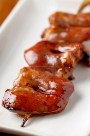 Photo for Closeup of wooden skewer with fried meat pieces - Royalty Free Image
