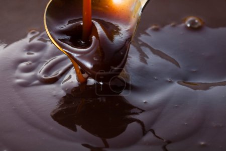 Photo for Thick dark sauce flowing from ladle - Royalty Free Image