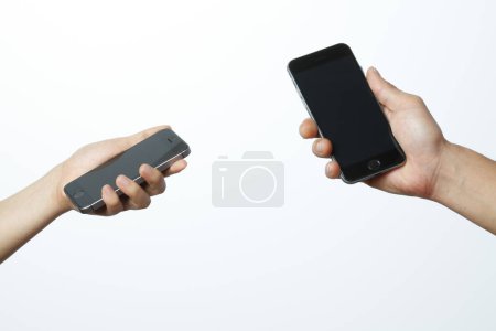 Photo for Two hands holding smartphones isolated on white background - Royalty Free Image