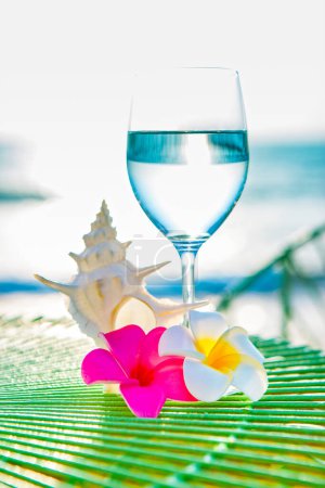 Foto de Vaso de agua sobre la mesa con el mar sobre el fondo - Imagen libre de derechos