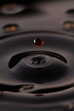 Foto de Gota de bebida oscura cayendo y creando círculos - Imagen libre de derechos