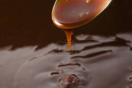 Photo for Pouring honey on dark chocolate - Royalty Free Image