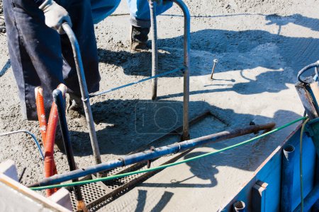 Foto de Trabajador que utiliza cemento para hacer piso en el sitio de construcción - Imagen libre de derechos