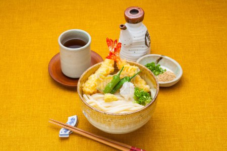Téléchargez les photos : Vue rapprochée de délicieux plats asiatiques avec du thé sur fond jaune - en image libre de droit