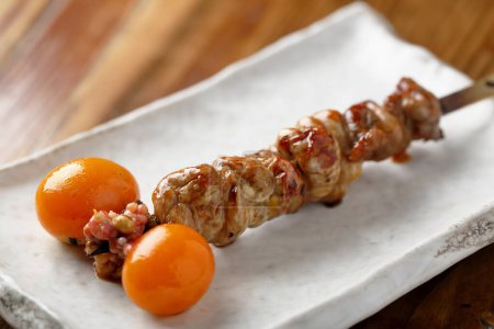 Photo for Closeup of wooden skewer with fried meat pieces - Royalty Free Image