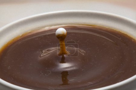 Téléchargez les photos : Baisse de lait tombant dans le café - en image libre de droit