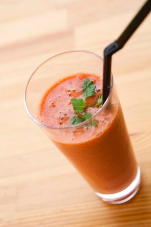 Téléchargez les photos : Verre de jus de tomate savoureux avec paille à boire sur une table en bois - en image libre de droit