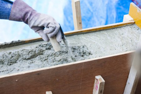 Photo for Worker using cement at construction site, close up - Royalty Free Image