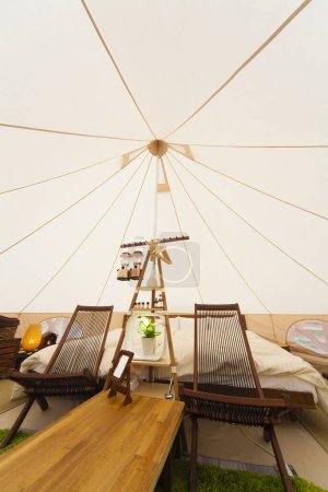 Photo for Interior of big white tent with bed and chairs - Royalty Free Image