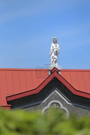 Téléchargez les photos : Statue blanche sur le toit rouge de l'église - en image libre de droit