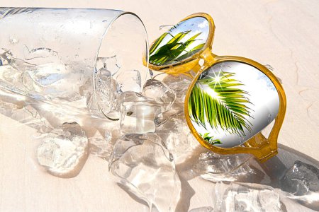 Foto de Vaso de agua con cubitos de hielo y gafas de sol amarillas sobre fondo blanco, concepto de vacaciones de verano y relajación en un día soleado, espacio para copiar - Imagen libre de derechos