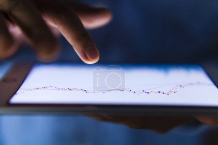 Photo for Close-up view of Business person analyzing financial statistics displayed on the tablet screen - Royalty Free Image