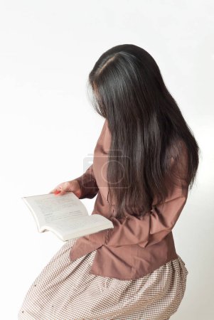 Foto de Retrato de mujer joven asiática leyendo libro viejo sobre fondo blanco - Imagen libre de derechos