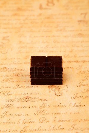 Photo for Close-up view of chocolate pieces on brown vintage table - Royalty Free Image