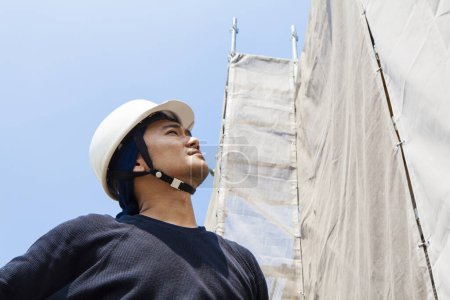 Téléchargez les photos : Portrait d'un beau japonais posant sur le chantier - en image libre de droit