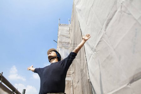 Foto de Retrato de trabajador japonés guapo posando en el sitio de construcción - Imagen libre de derechos
