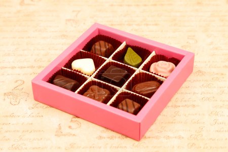 Foto de Caramelos de chocolate en caja sobre fondo, de cerca - Imagen libre de derechos