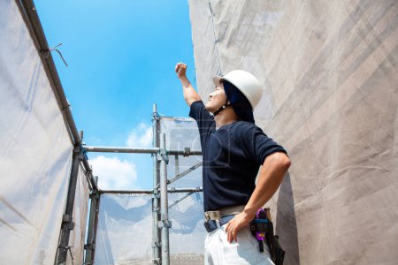 Foto de Retrato de trabajador japonés guapo posando en el sitio de construcción - Imagen libre de derechos