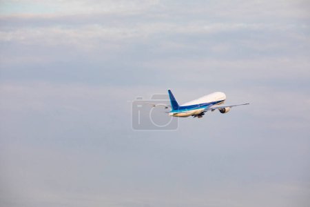 Photo for Passenger airplane in the blue cloudy sky - Royalty Free Image
