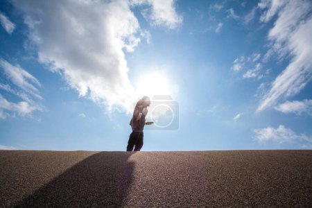 Photo for Asian businessman with phone on sandy beach - Royalty Free Image