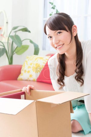 Téléchargez les photos : Femme déménagement maison avec boîte en carton - en image libre de droit