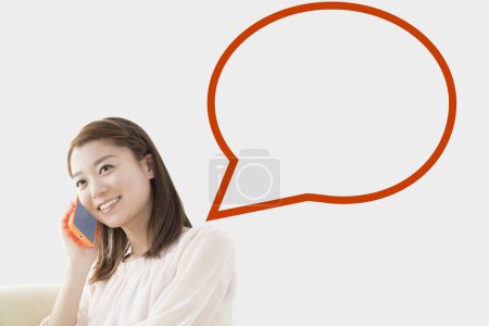 Téléchargez les photos : Souriant japonais femme parler sur téléphone mobile avec vide bulle de parole - en image libre de droit