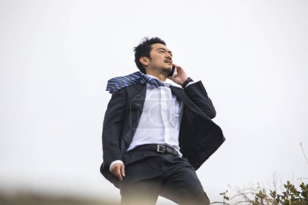 Foto de Joven asiático hombre de negocios hablando por teléfono - Imagen libre de derechos