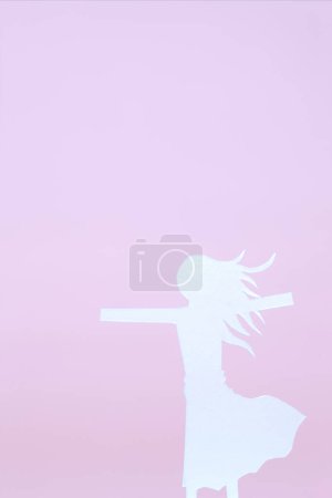 Silhouette of woman made from paper isolated on pink background
