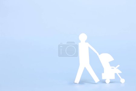 Téléchargez les photos : Poussette bébé avec figurine en papier sur le fond . - en image libre de droit
