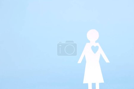Foto de Figura femenina cortada en papel con corazón aislado sobre fondo. - Imagen libre de derechos