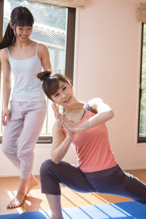 Photo for Young asian women exercising together at home in living room - Royalty Free Image
