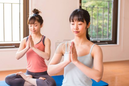 Photo for Asian women doing yoga in gym, relaxation concept - Royalty Free Image