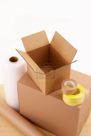 Foto de Cajas de cartón con rollos de papel y cintas adhesivas sobre fondo blanco - Imagen libre de derechos